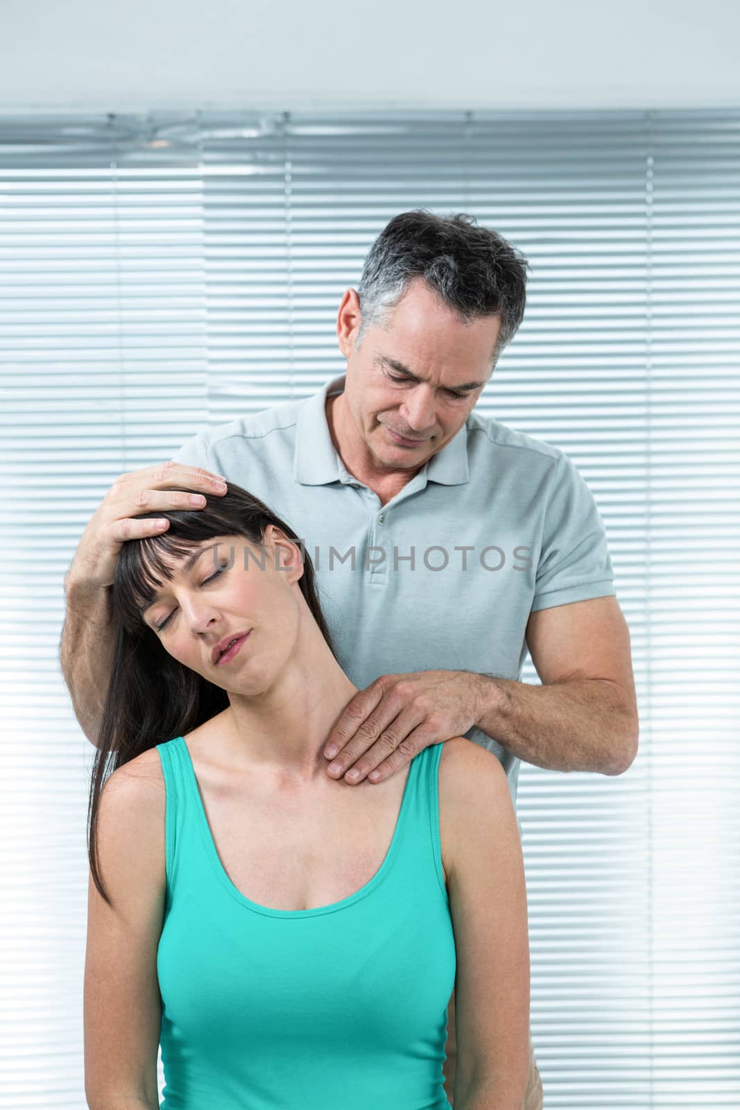 Physiotherapist checking pregnant womans neck by Wavebreakmedia