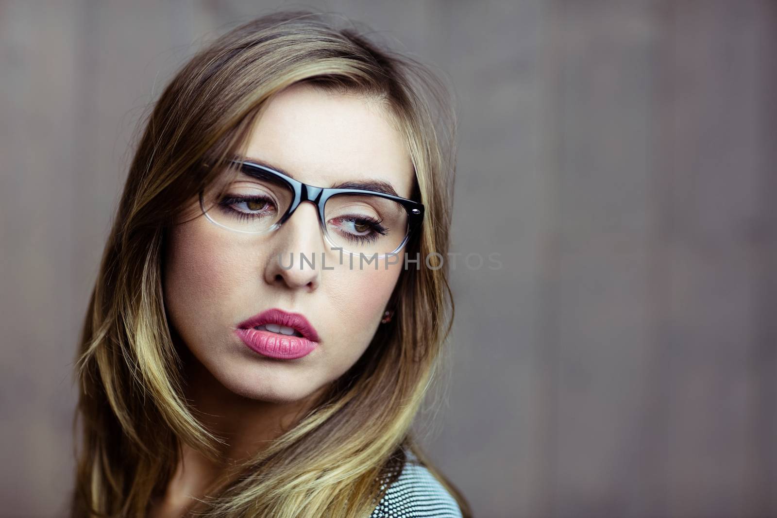 Pretty blonde woman day dreaming on wooden background