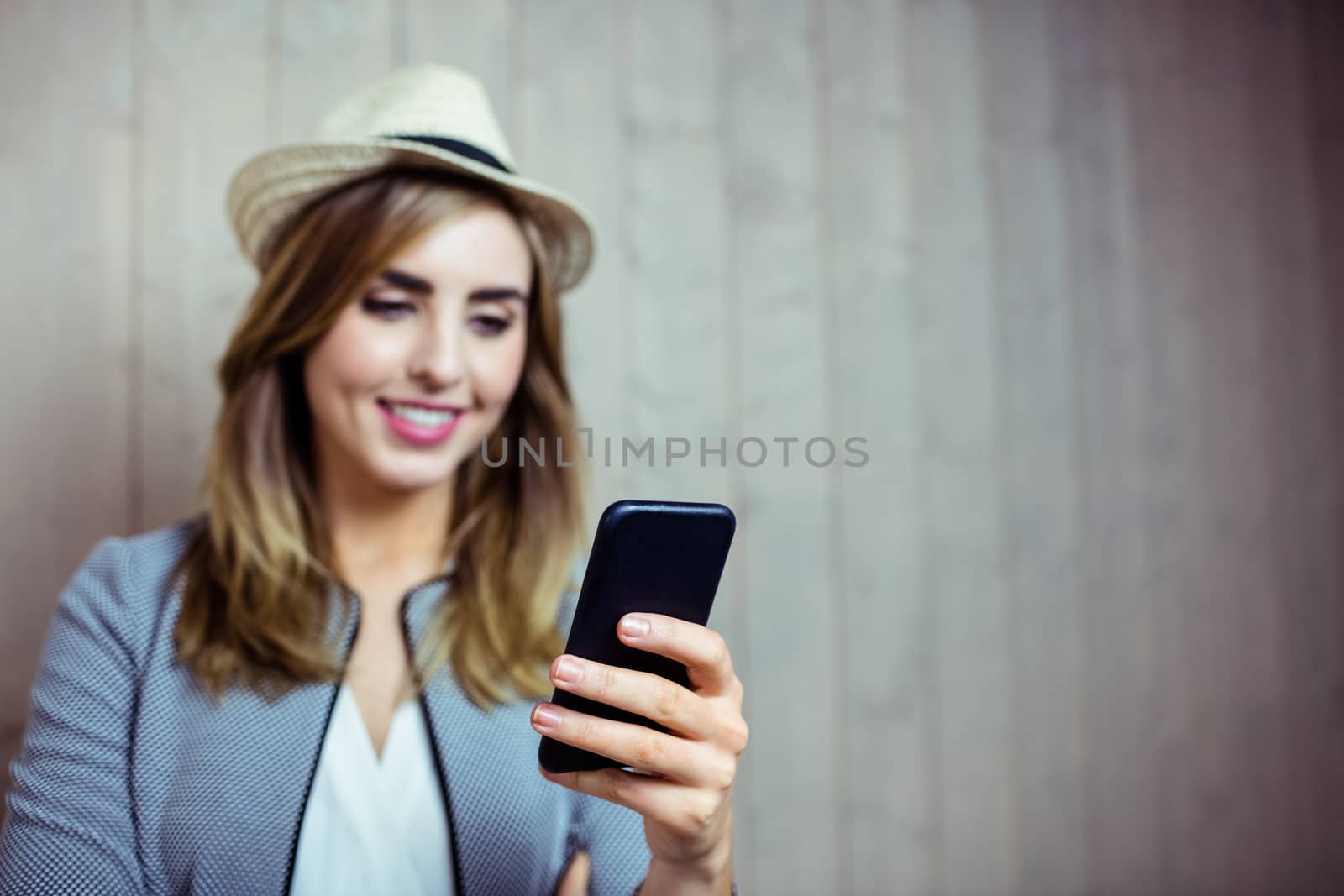 Pretty woman using smartphone on wooden background