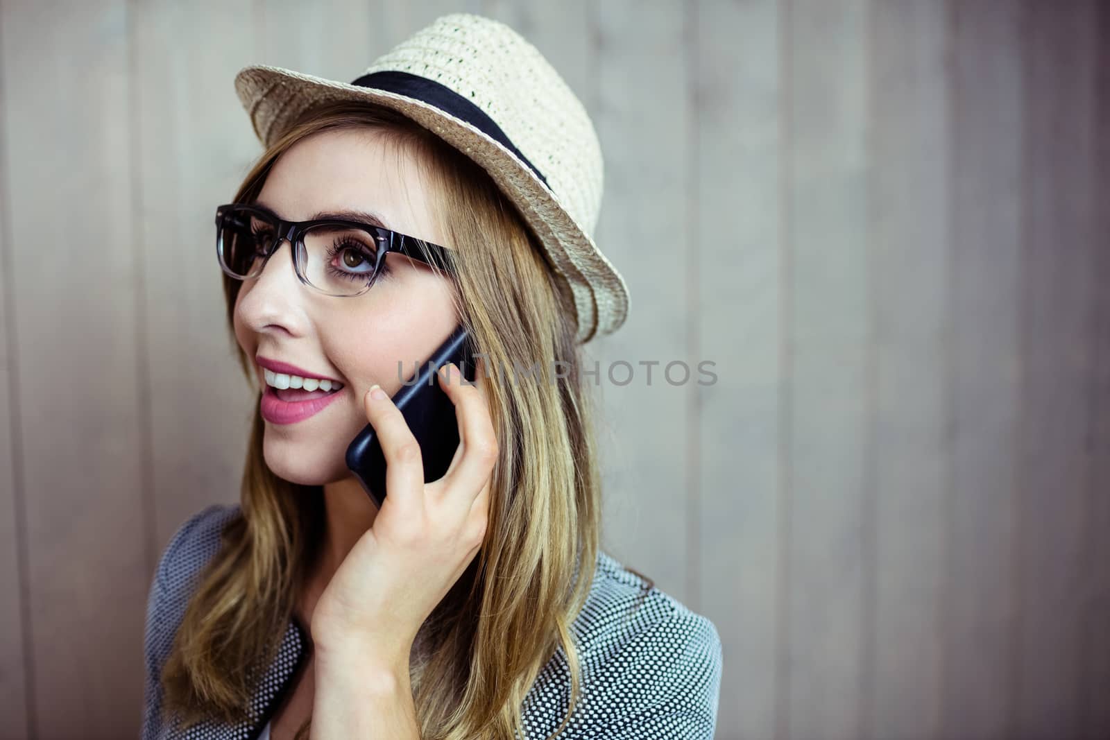 Pretty blonde woman on the phone on wooden background