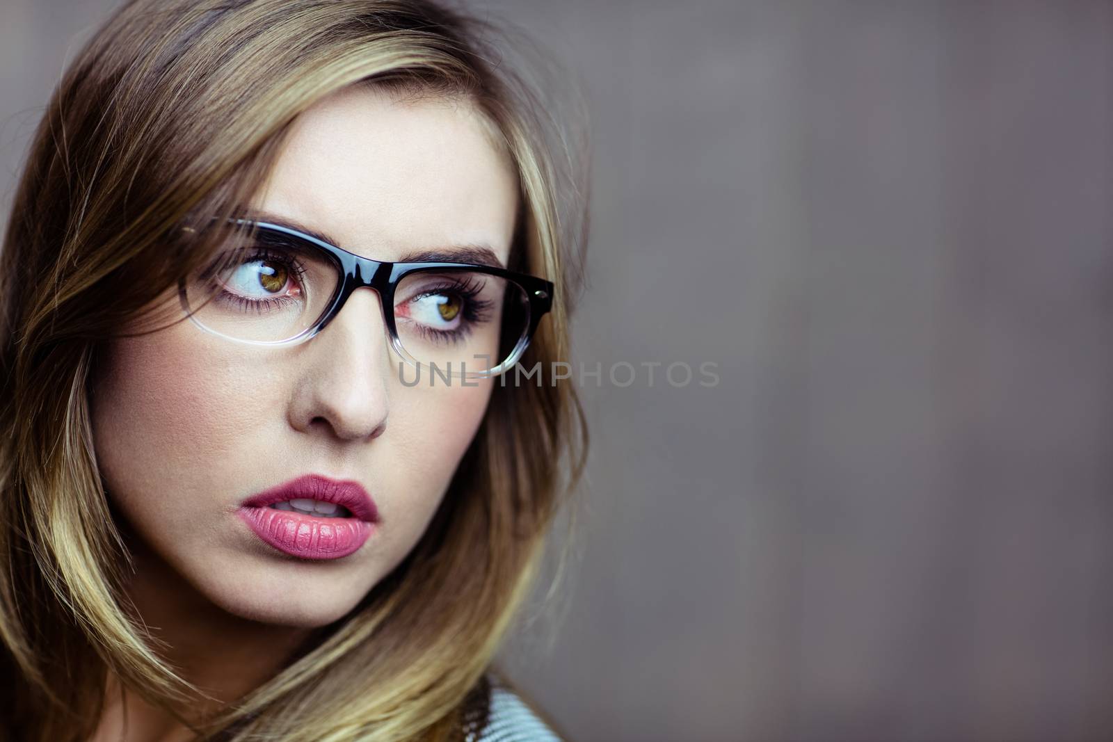 Pretty blonde woman day dreaming on wooden background