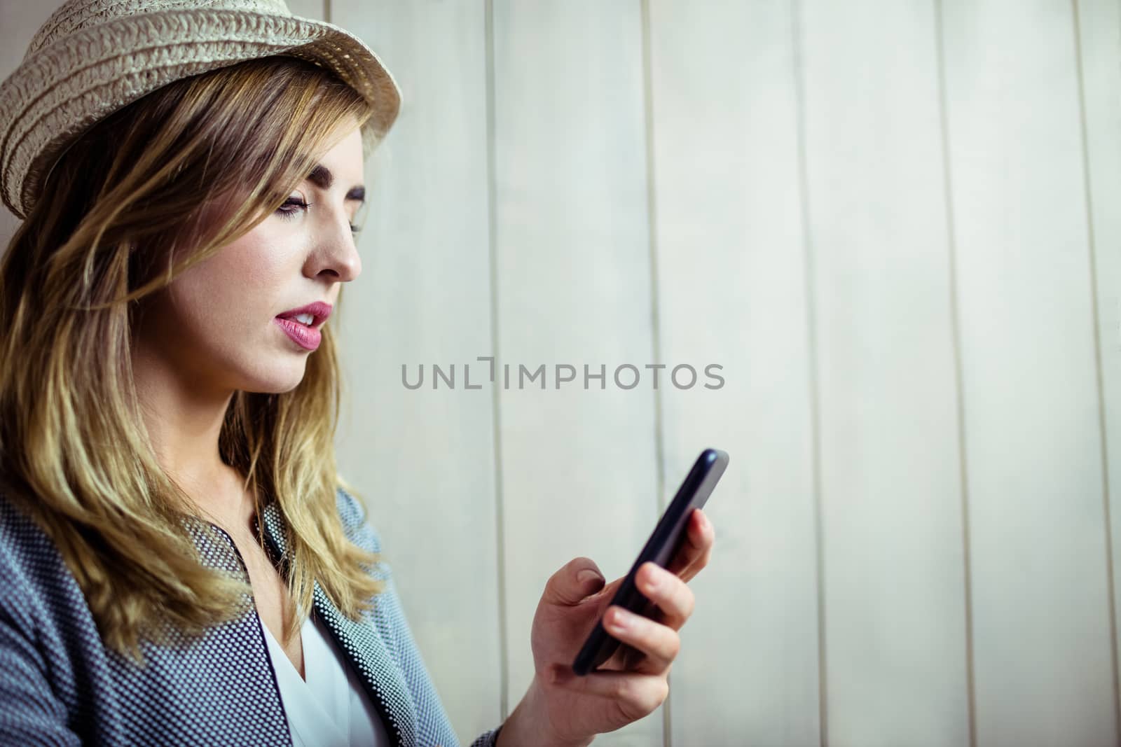 Pretty woman using smartphone on wooden background