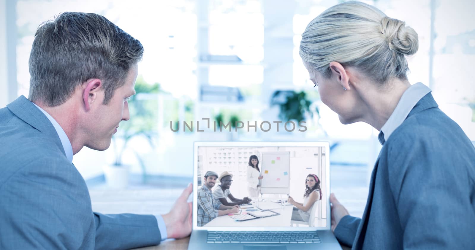 Business people looking at blank screen of laptop against smiling businessman and colleagues looking at camera