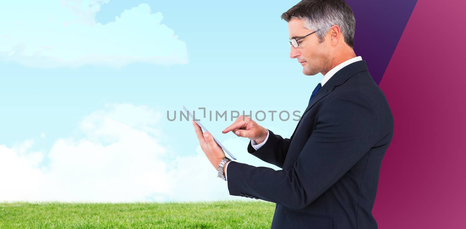 Mid section of a businessman touching tablet against grassy field against sky