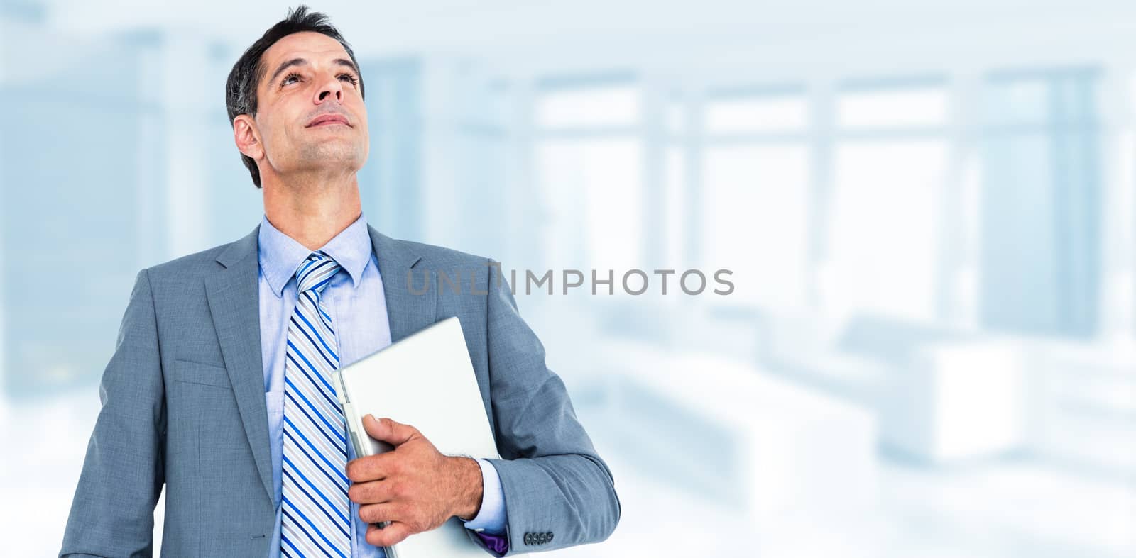 excited cheering businessman holding his laptop against modern room overlooking city