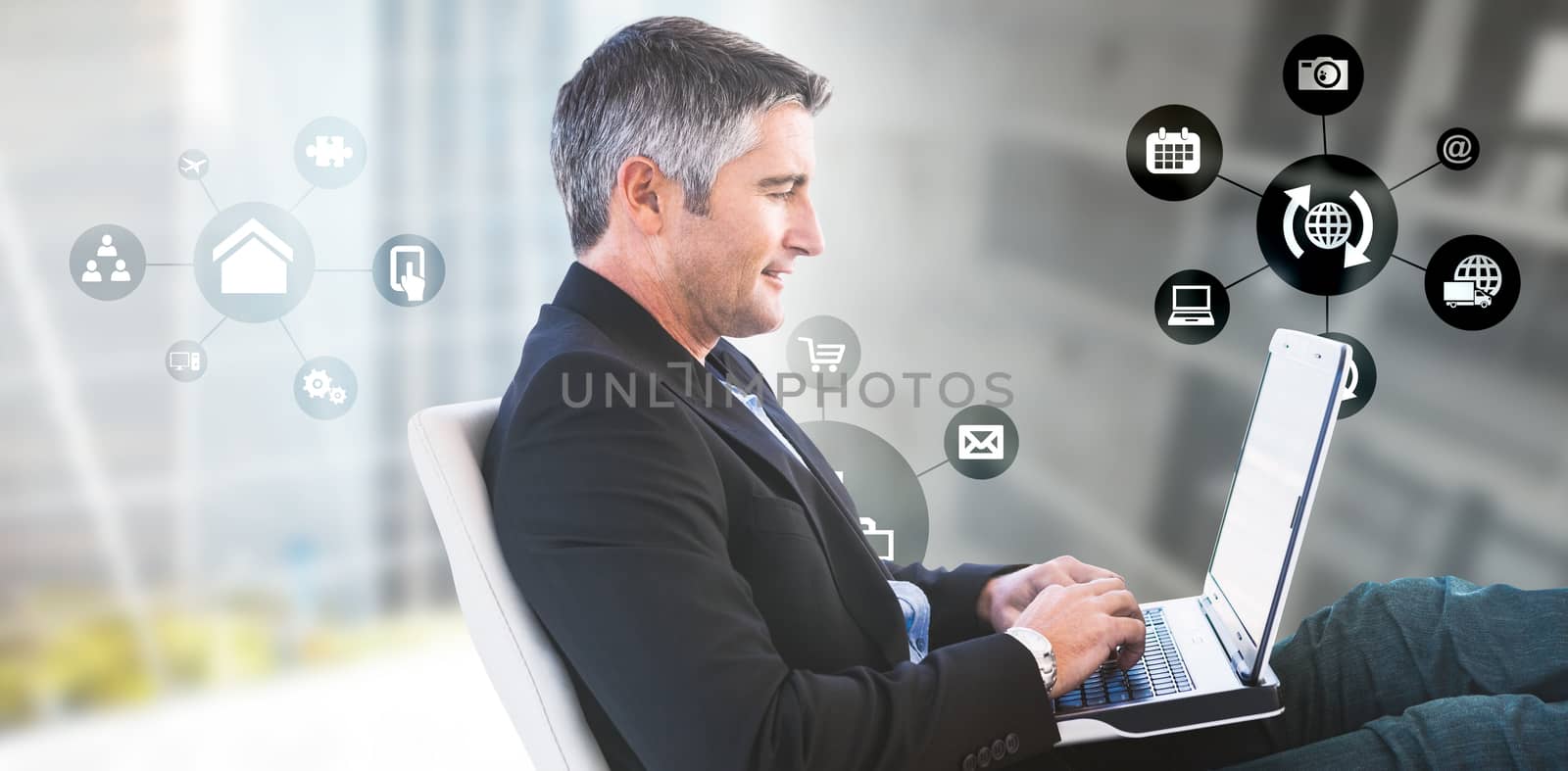 Businessman using laptop against modern room overlooking city