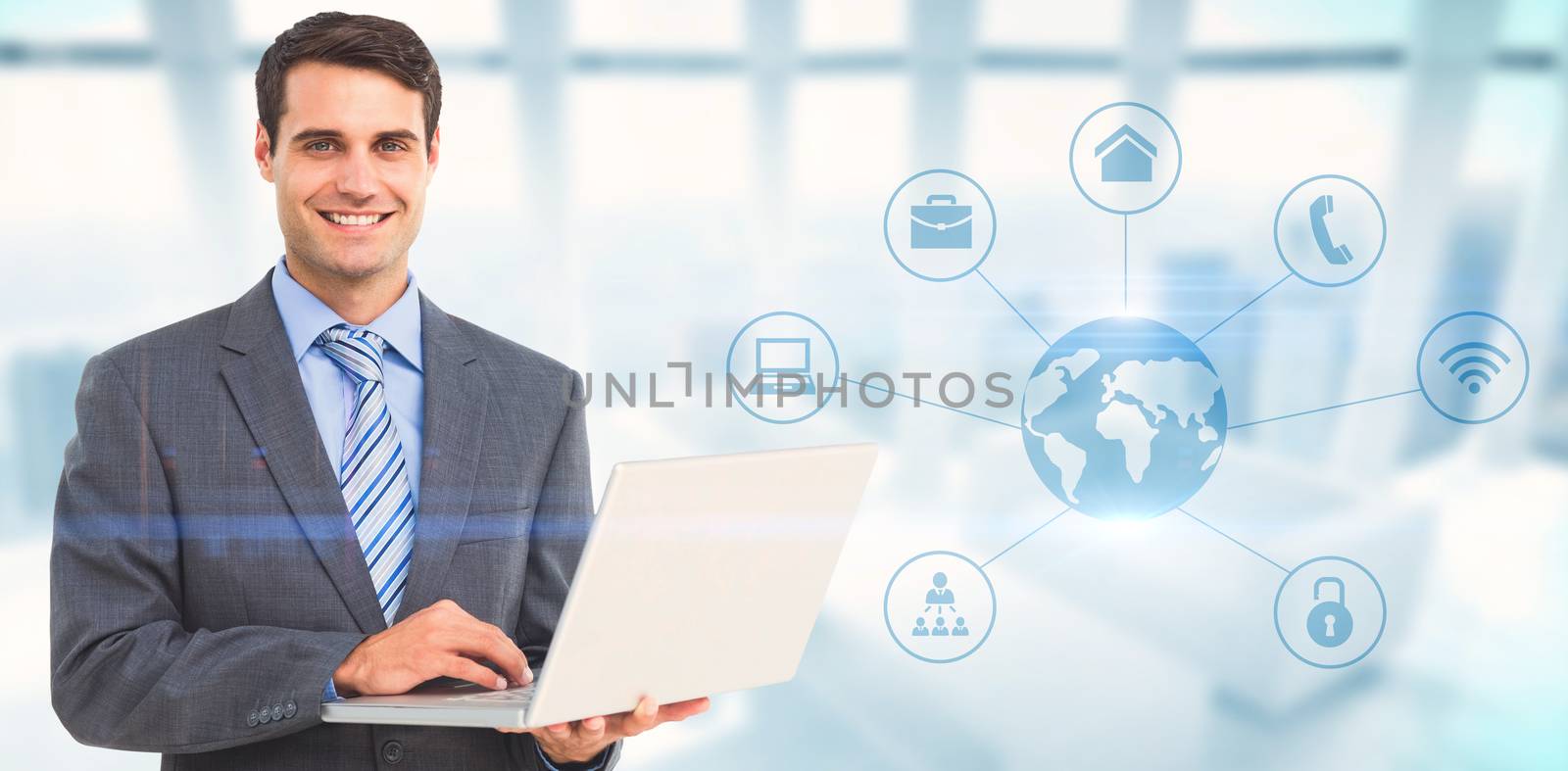 Portrait of smiling businessman using laptop against modern room overlooking city