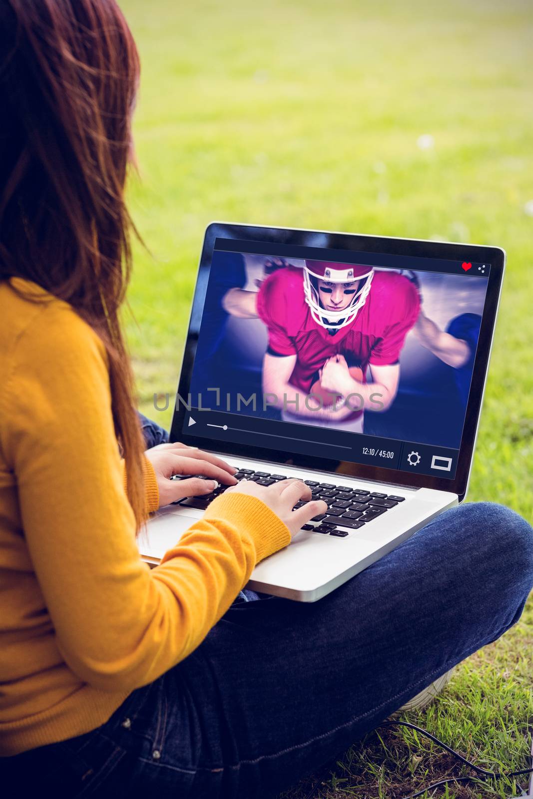 Woman using laptop in park against composite image of american football players