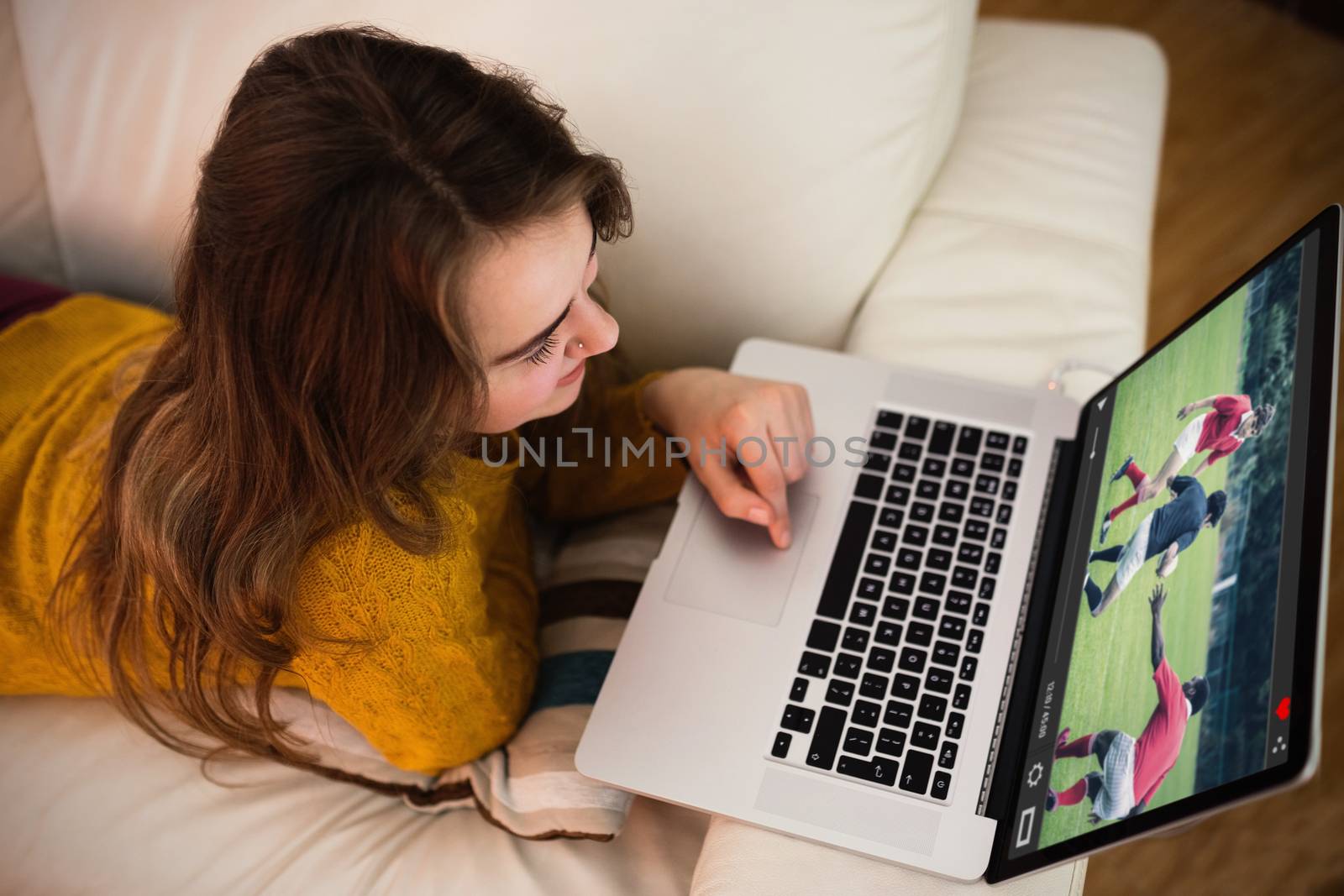 View of lecture app against young woman using her laptop lying on the couch
