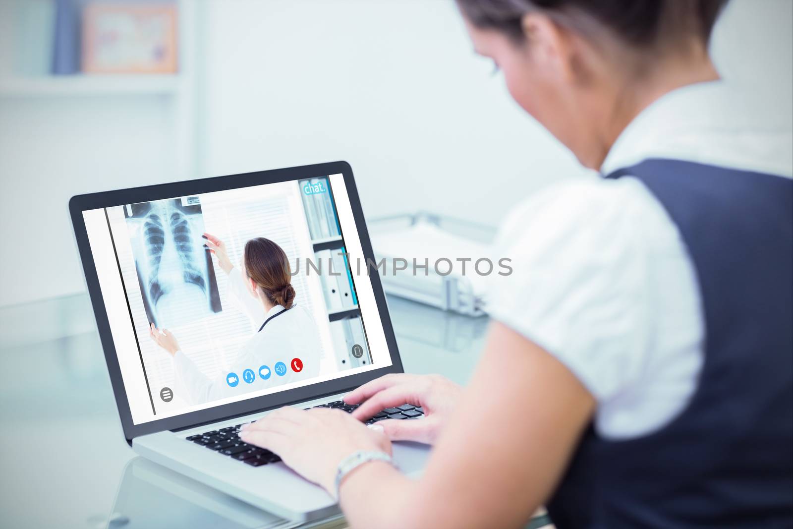 Female doctor studying Xray against business worker using laptop at desk