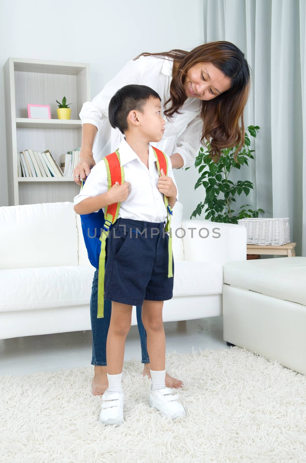 Asian mother get her son ready to school