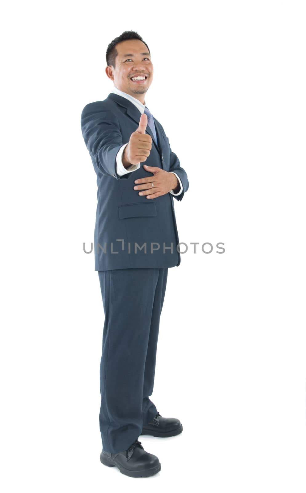 Excited thumb up 40s Indonesian businessman in black suit isolated on white background