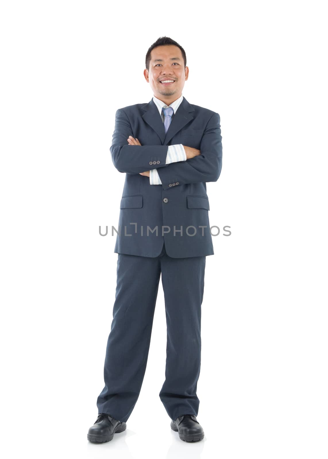 Confident Southeast Asian businessman crossed arms over white background