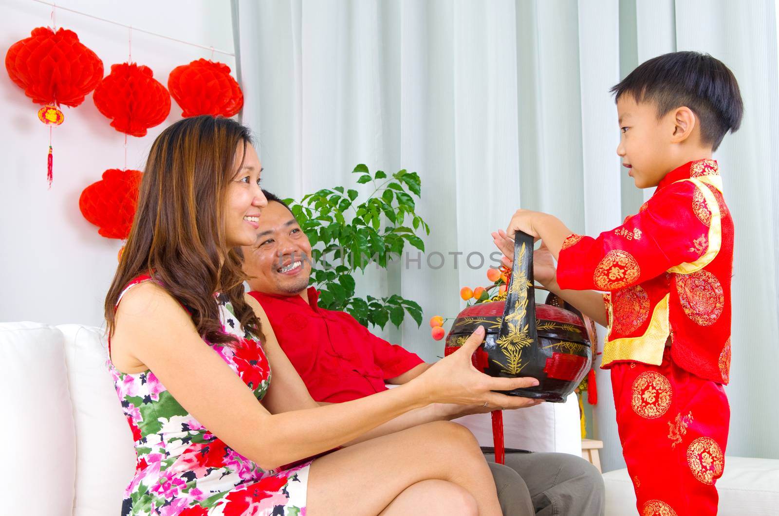 Asian boys presenting gift basket to parents on chinese new year