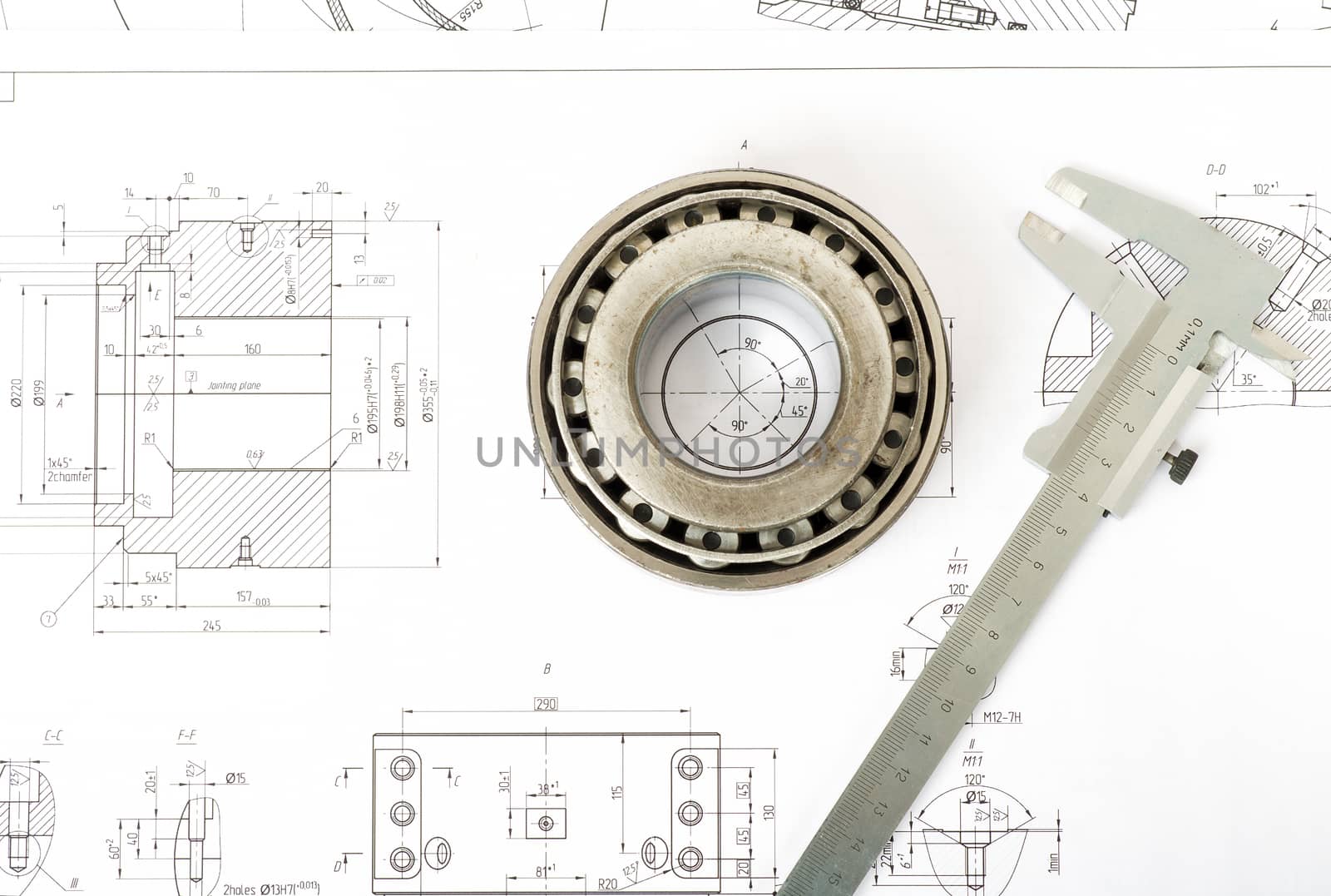 Roller bearing on blue prints with tool, top view