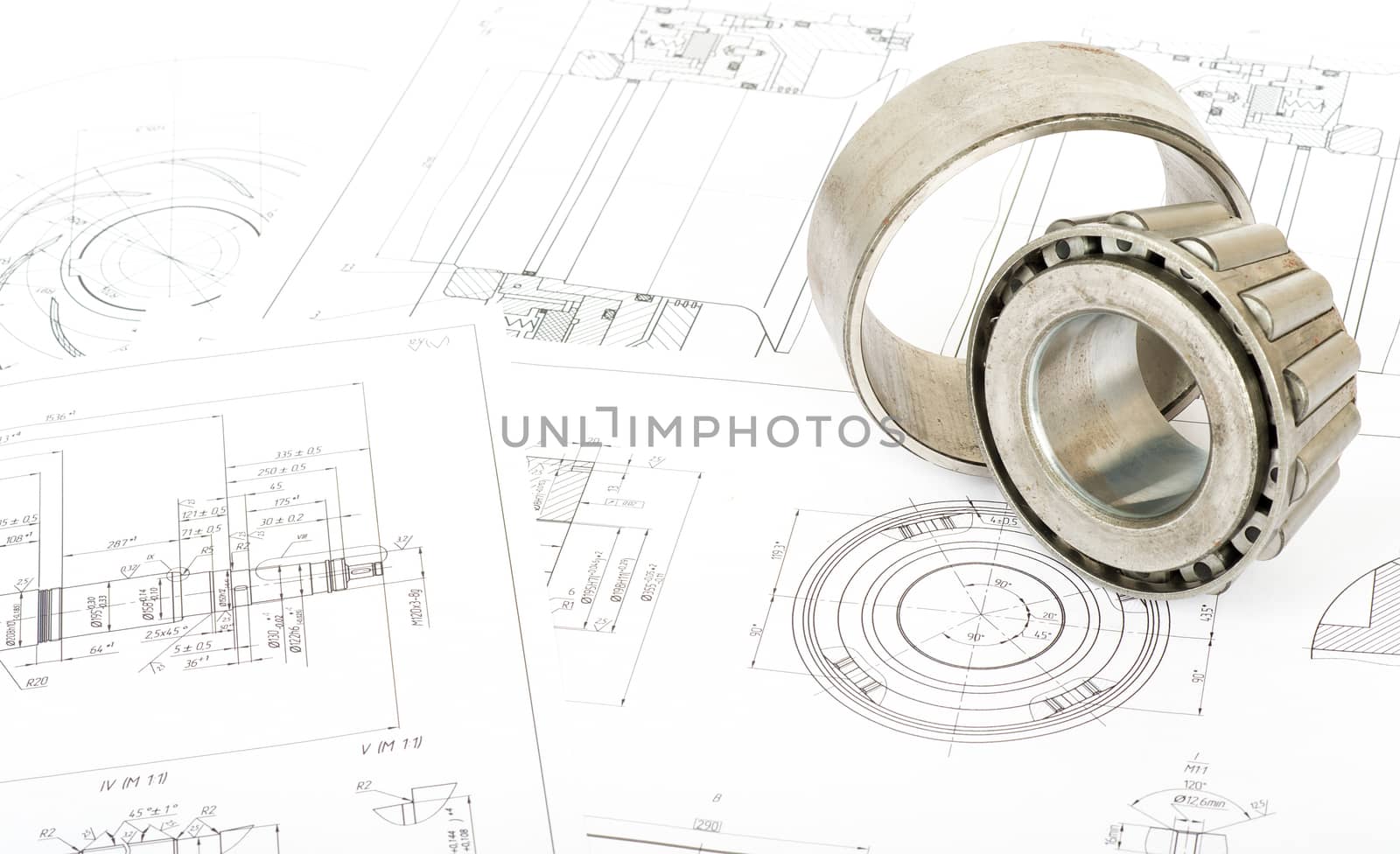 Roller bearing on blue prints, close up view