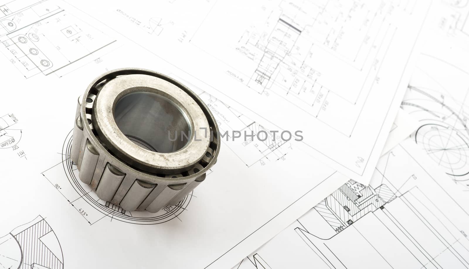 Roller bearing on blue prints, close up view