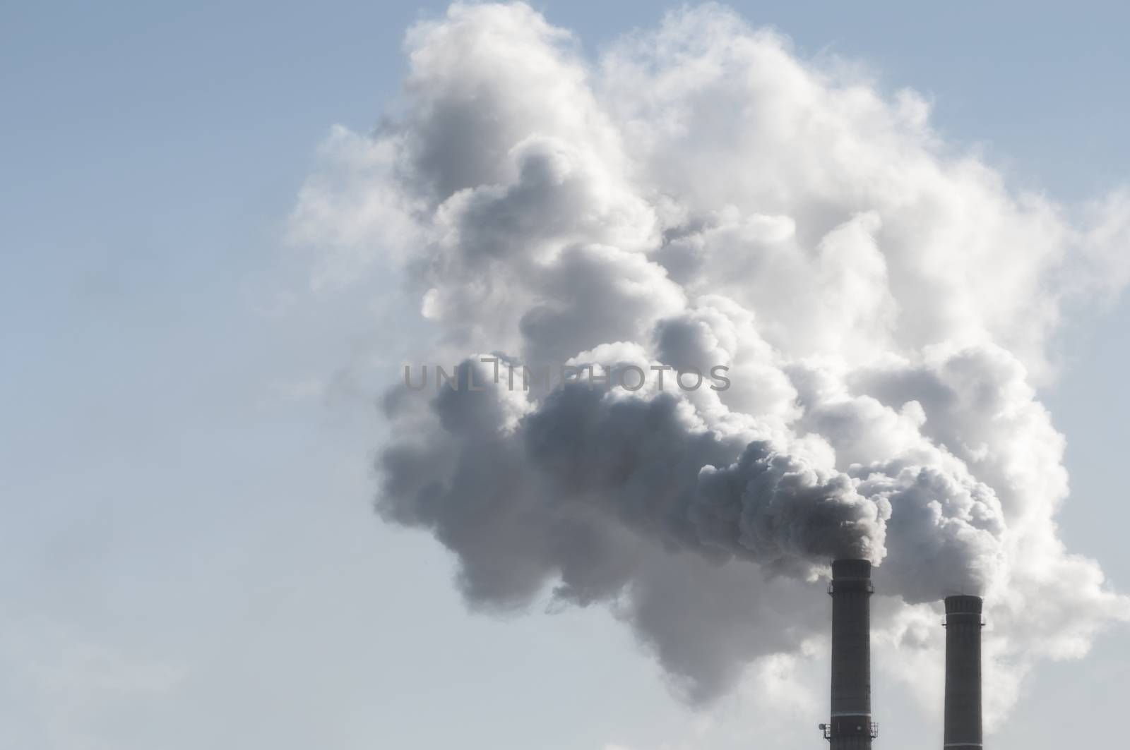 industrial smoke from chimney on blue sky