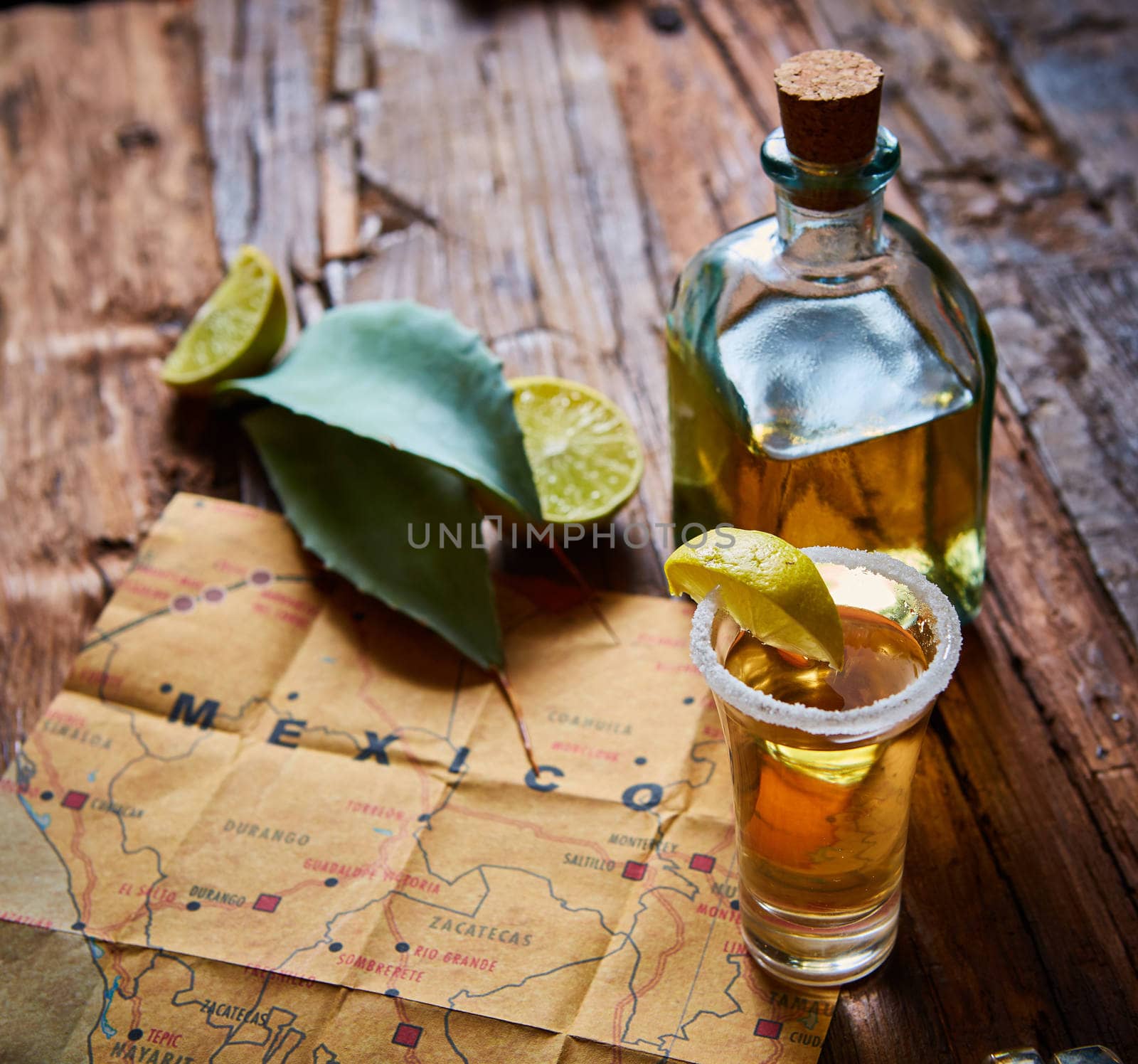 Tequila shot with lime and sea salt on wooden table, selective focus