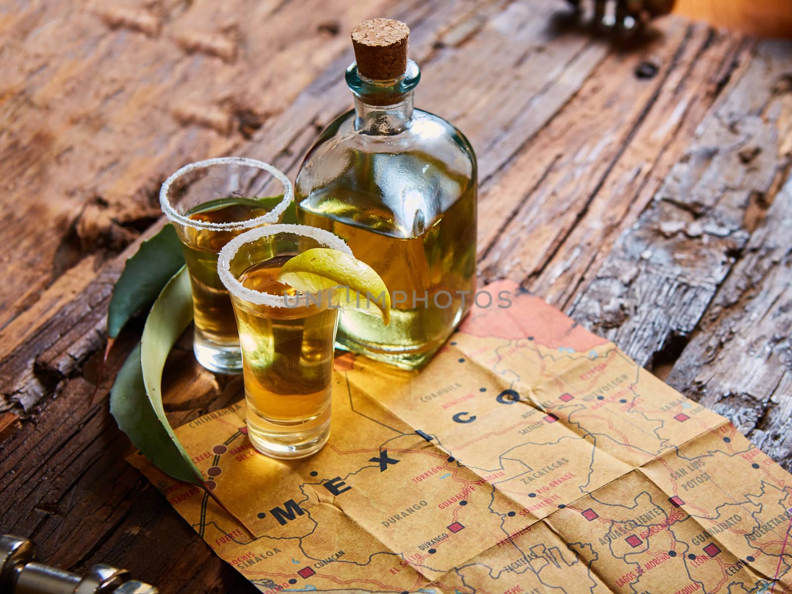 Tequila shot with lime and sea salt on wooden table, selective focus