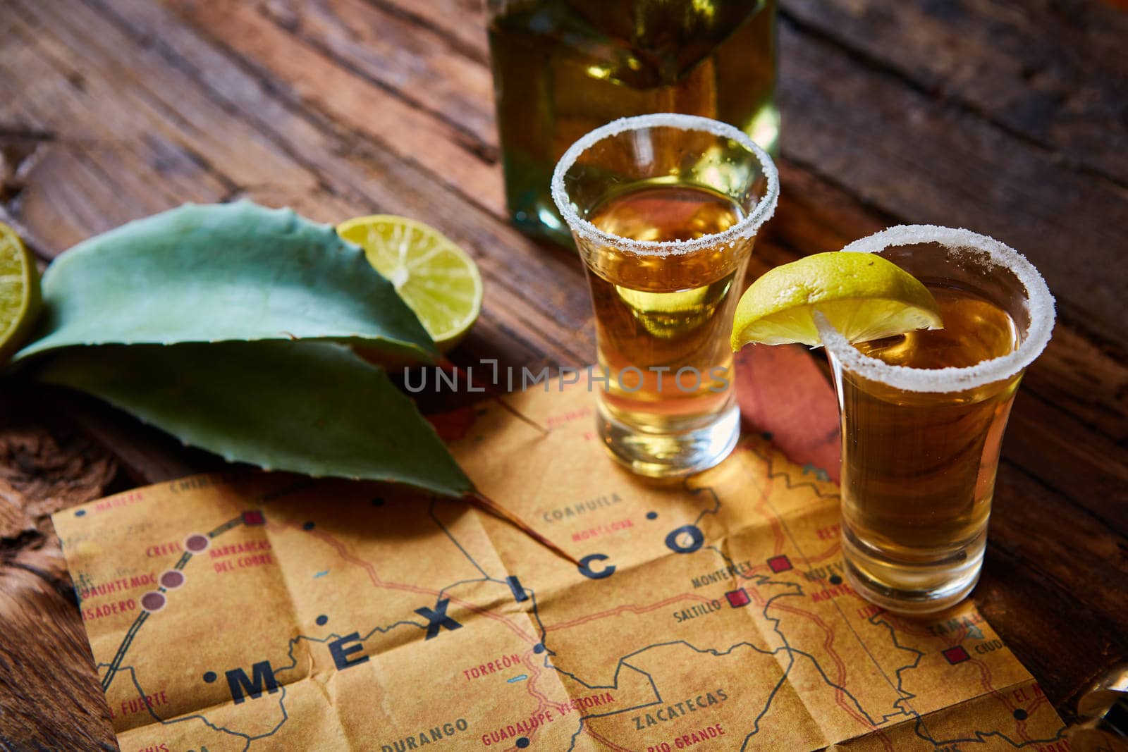 Tequila shot with lime and sea salt on wooden table, selective focus