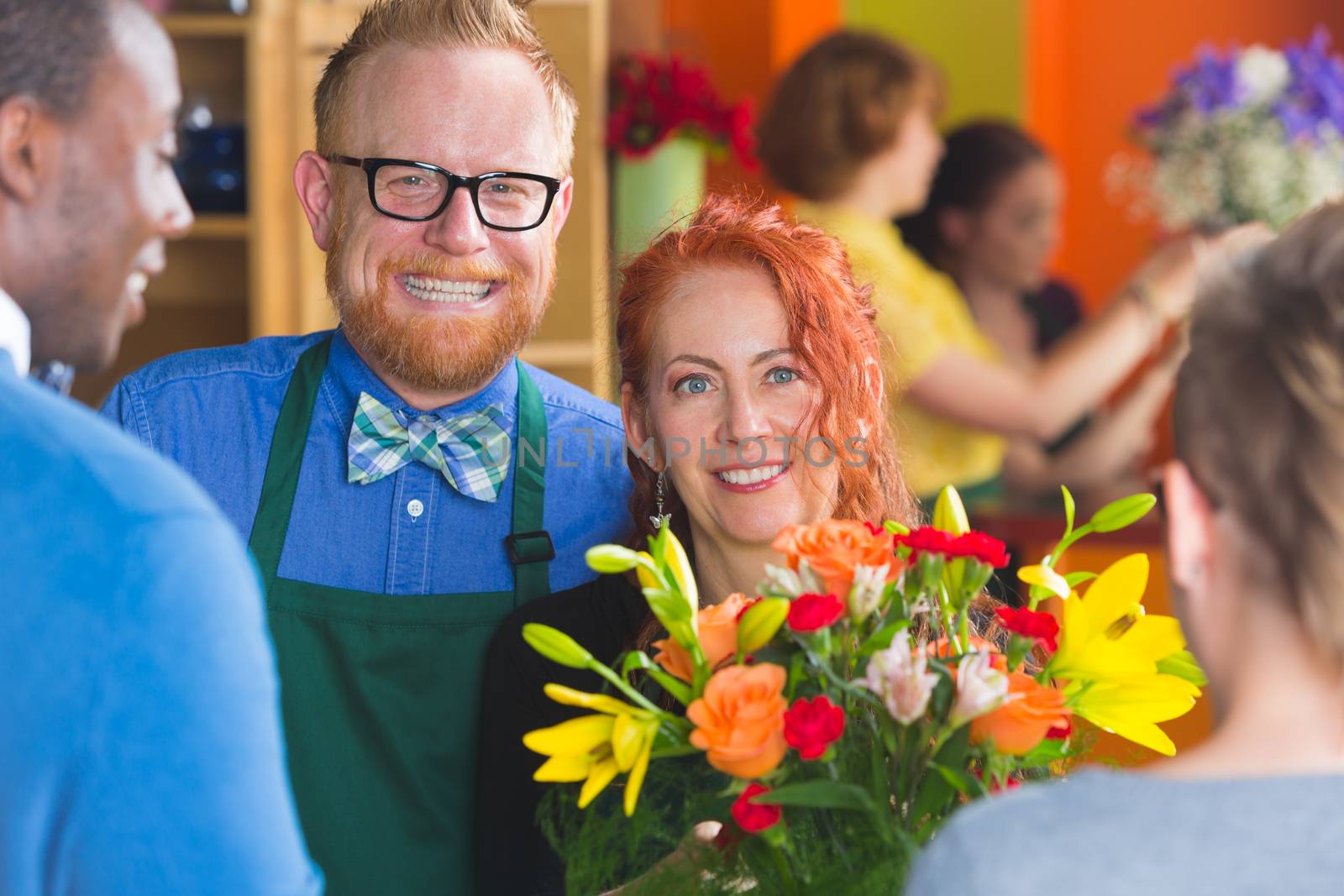 Friendly owners smile at customers in a busy flower shop