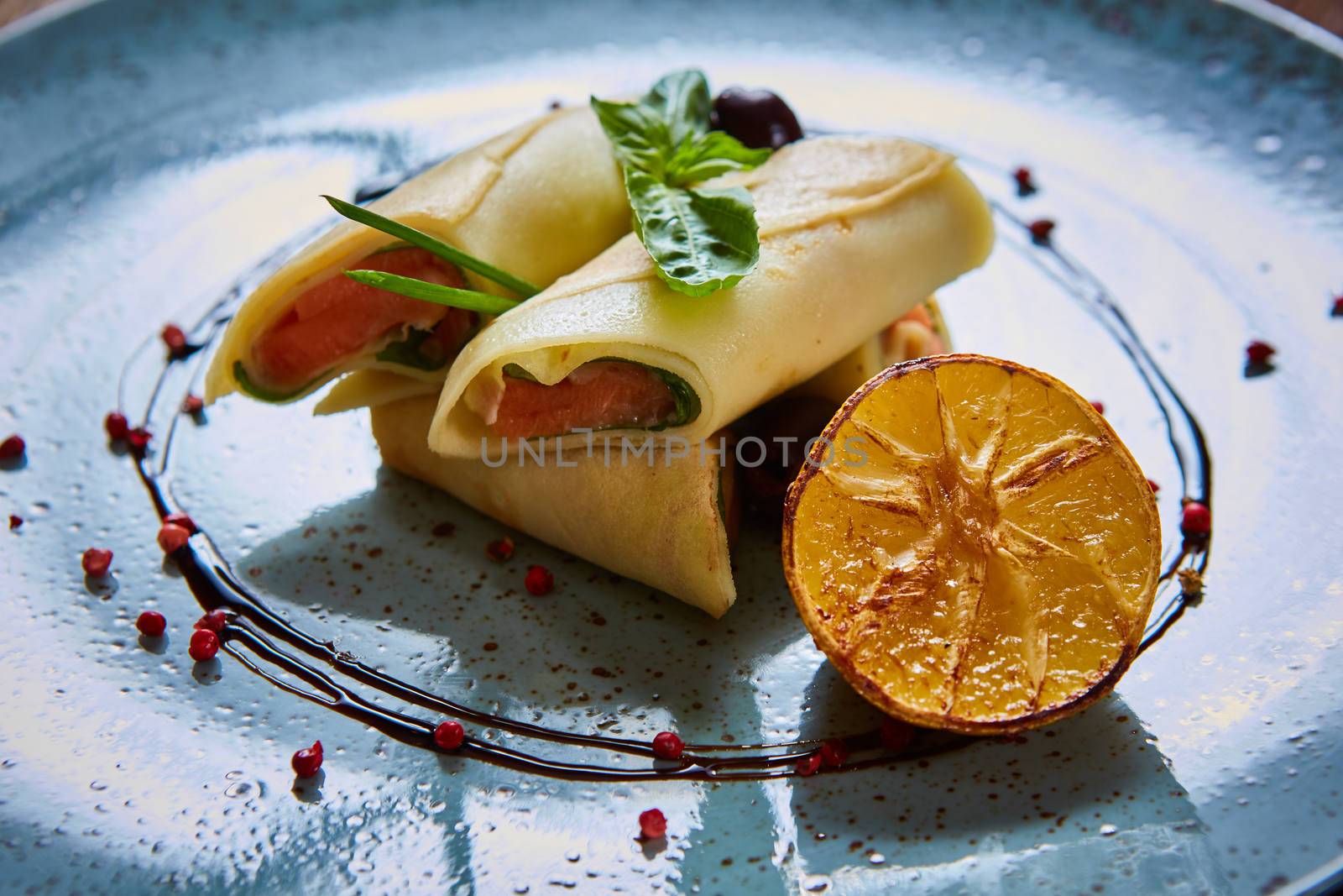 Crepes with smoked salmon on a blue plate for holiday