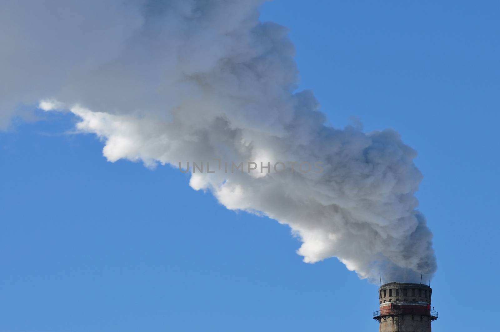 industrial smoke from chimney on blue sky day