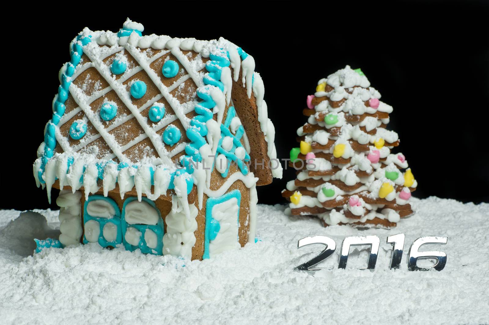 Gingerbread house and christmas tree with number 2016 on snow