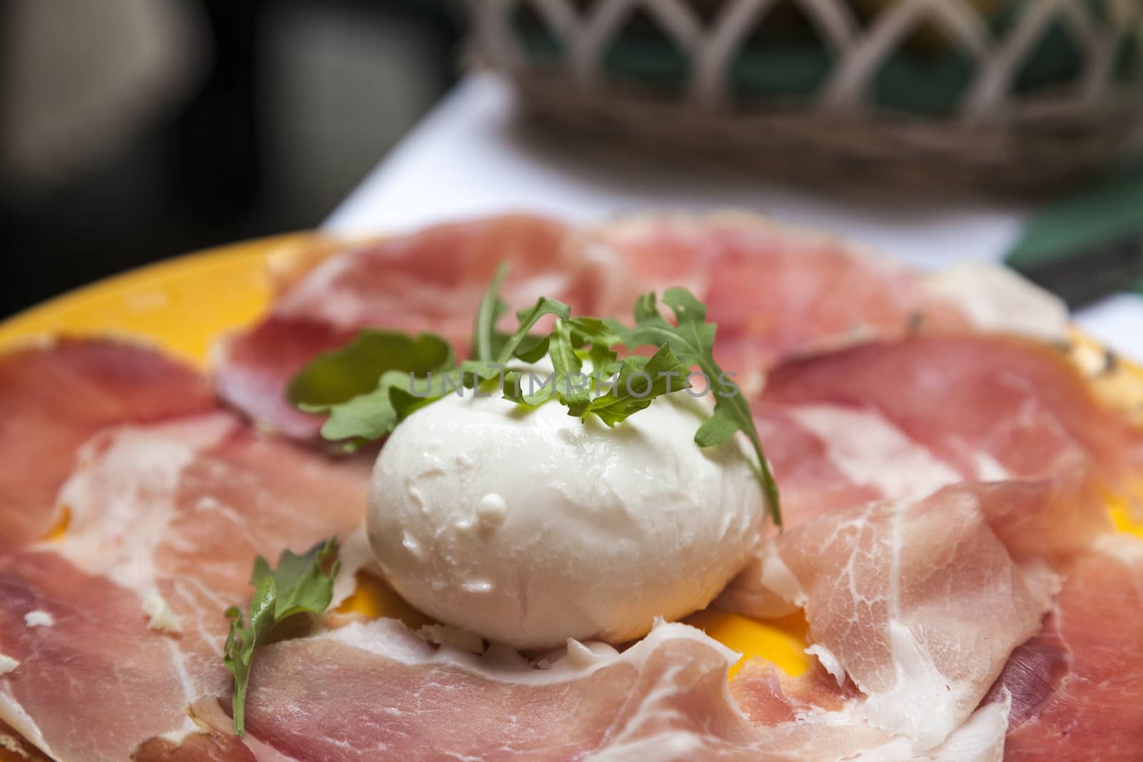 salad with parma  ham, mozzarella and rucola on plate.