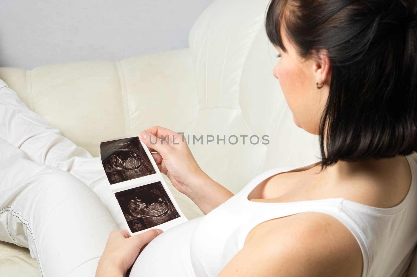 Pregnant woman looking at her baby ultrasound picture