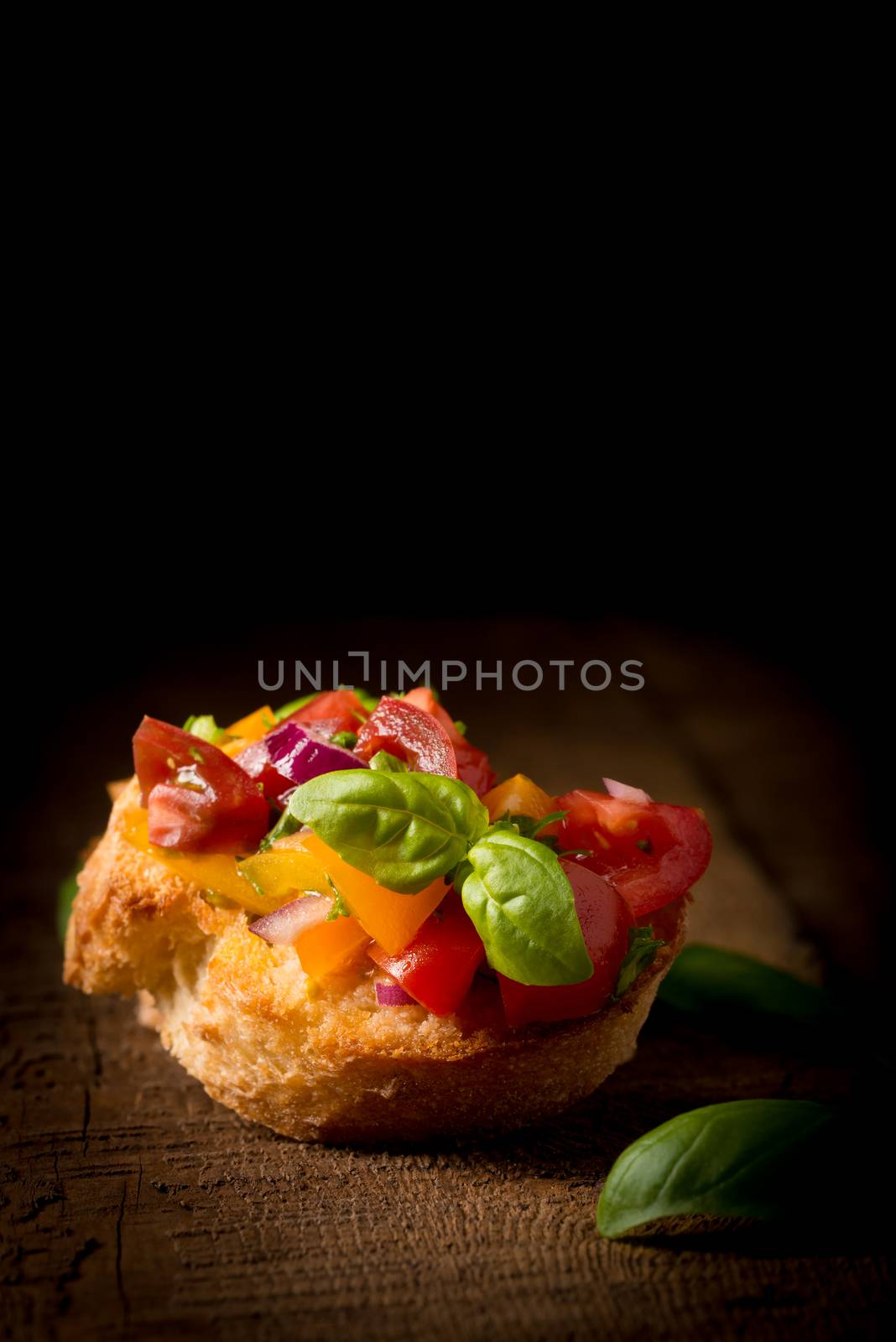 Colorful bruschetta on a rustic background.  Useful for many food service promotional applications.