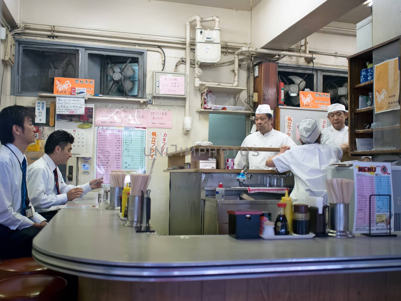 Tokyo, Japan - November 12, 2015: Waiter at sushi restaurant around Tsukiji fish market. Tsukiji is the biggest fish market in the world. The restaurants serve the world's freshest sushi.