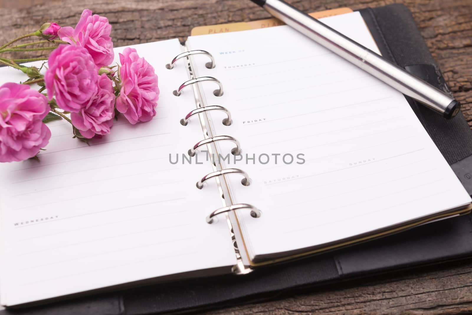 Diary note with pink rose on old wood (Organizer ,agenda, book, diary)