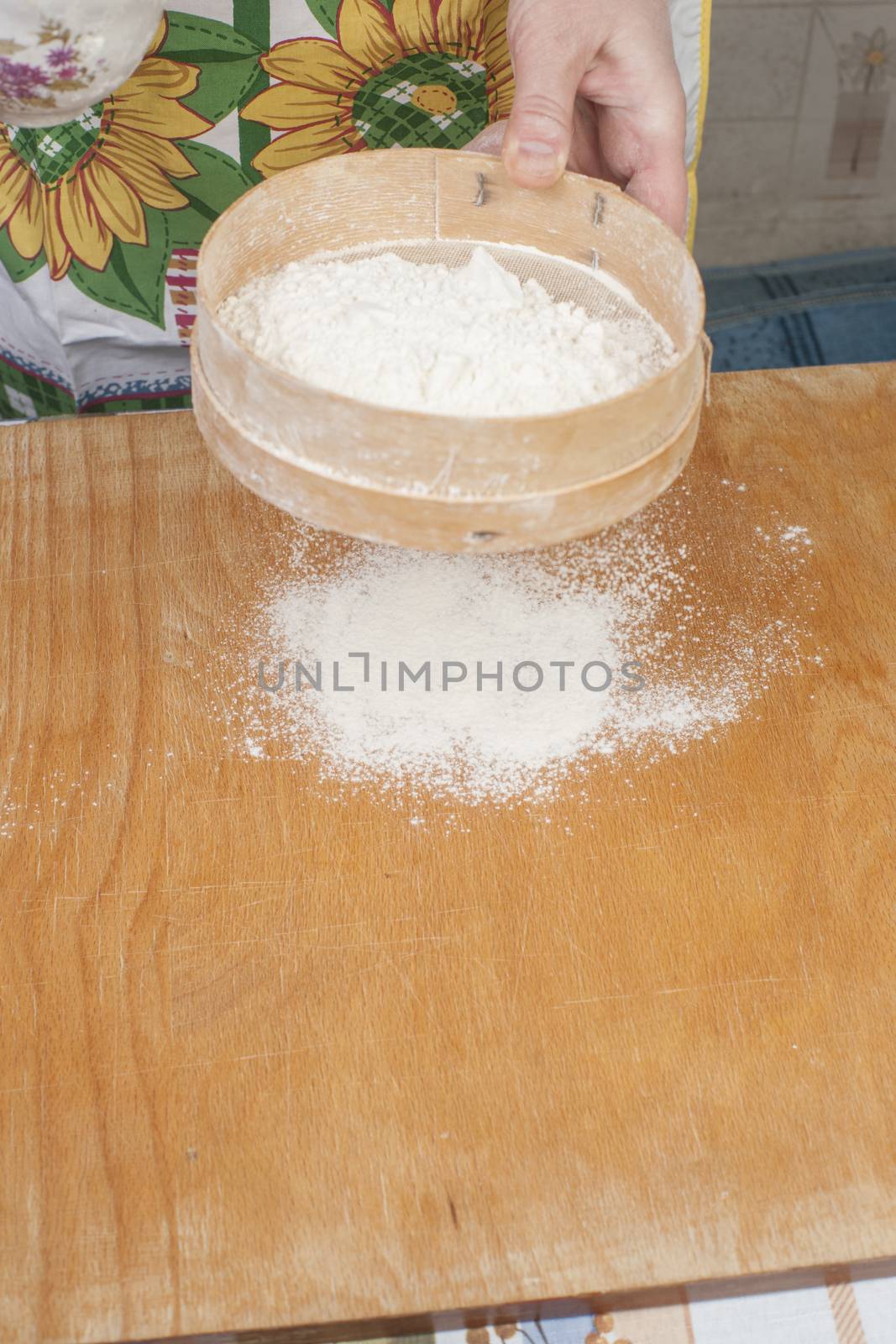 Women's hands prepairing flour before baking pie.