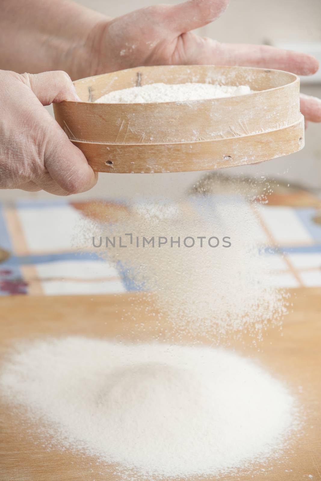 Women's hands prepairing flour before baking pie.