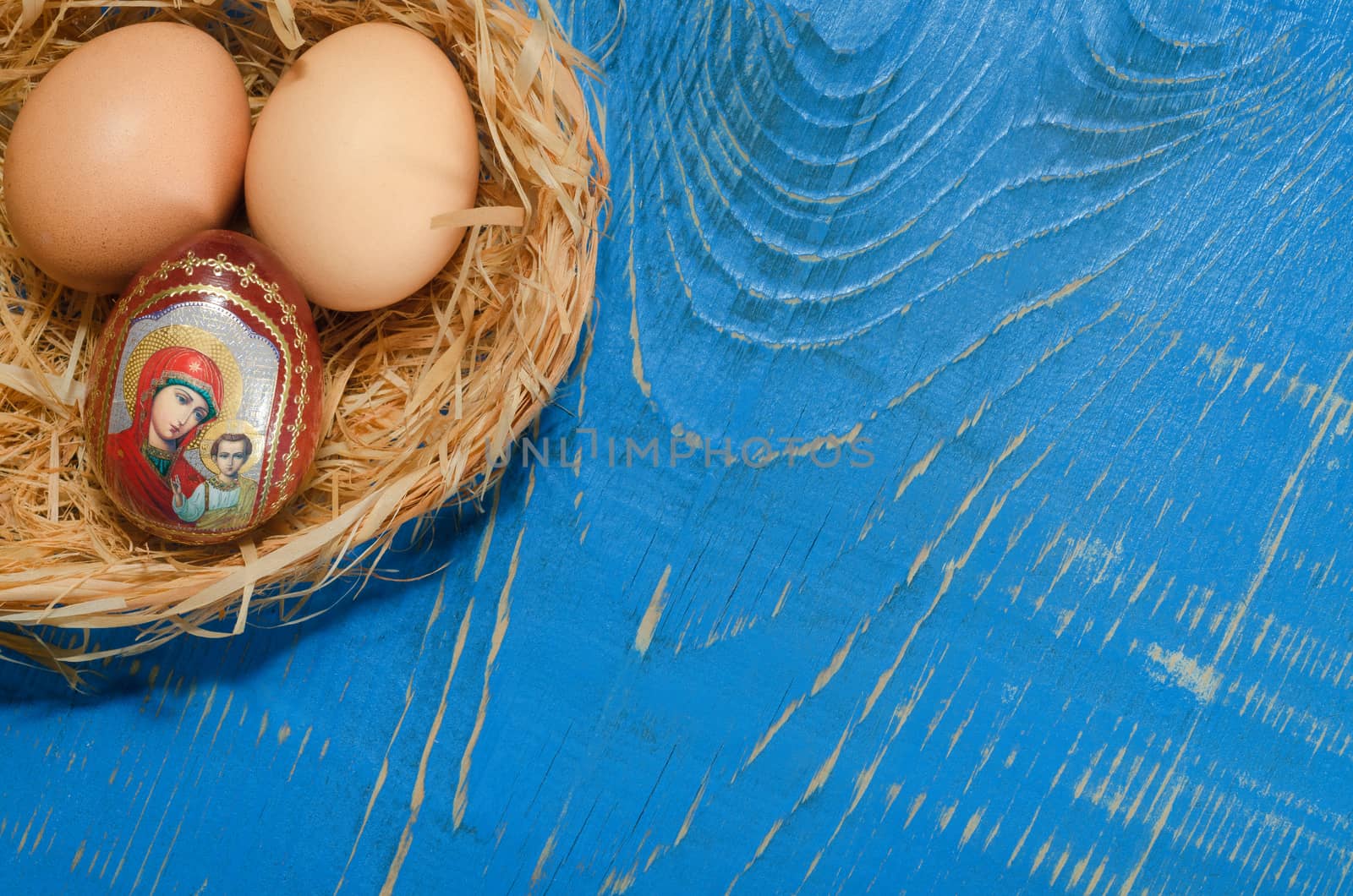 Eggs in the nest of bark, lying on a painted blue Board. On the Board, place for text.