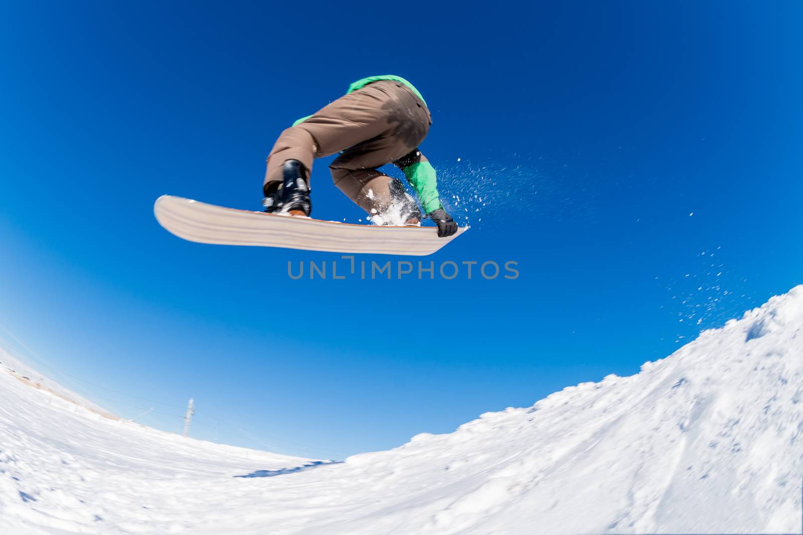 Snowboarder executing a radical jump against blue sky.