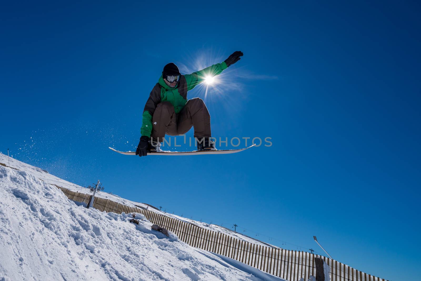 Snowboarder executing a radical jump against blue sky.