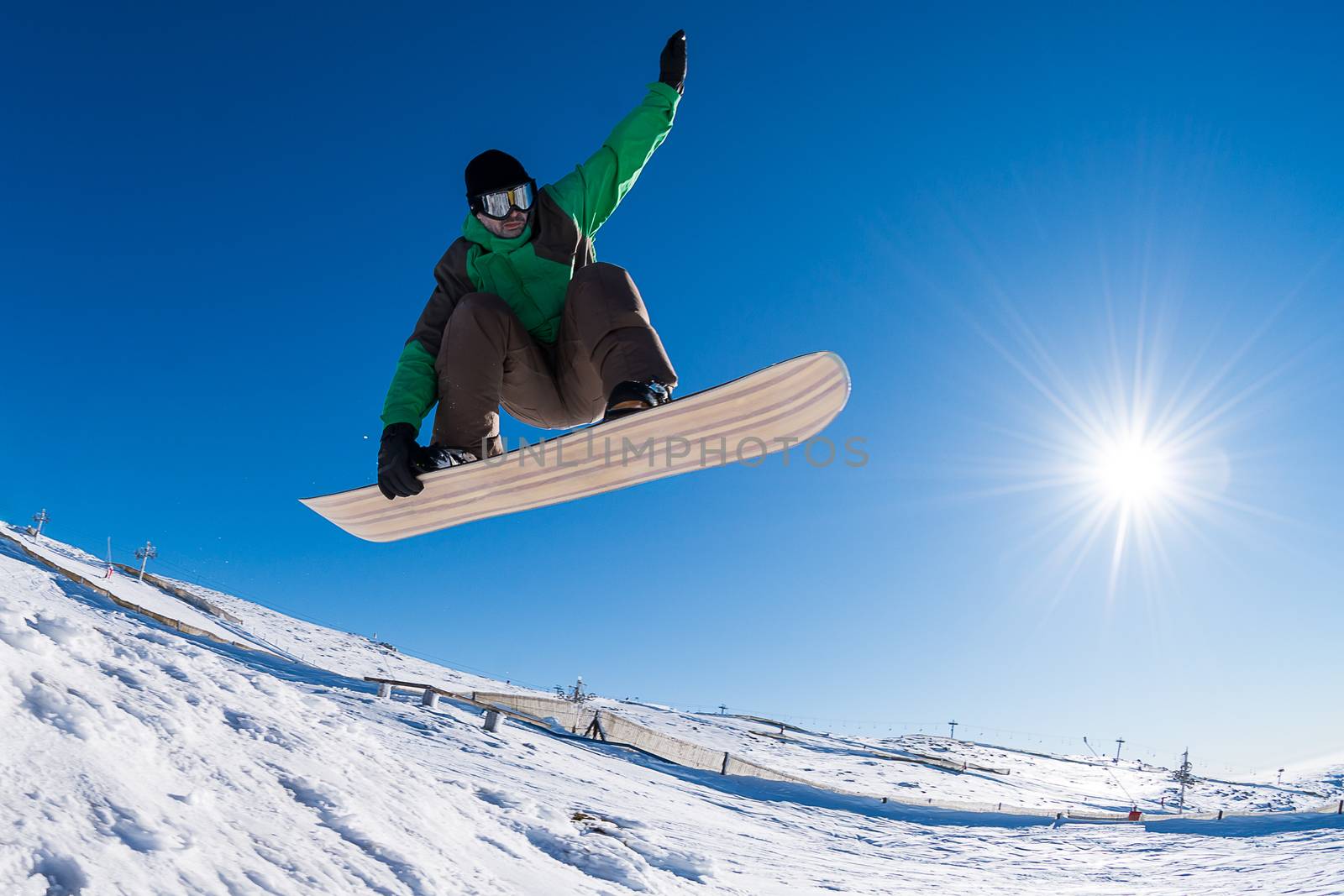 Snowboarder executing a radical jump against blue sky.