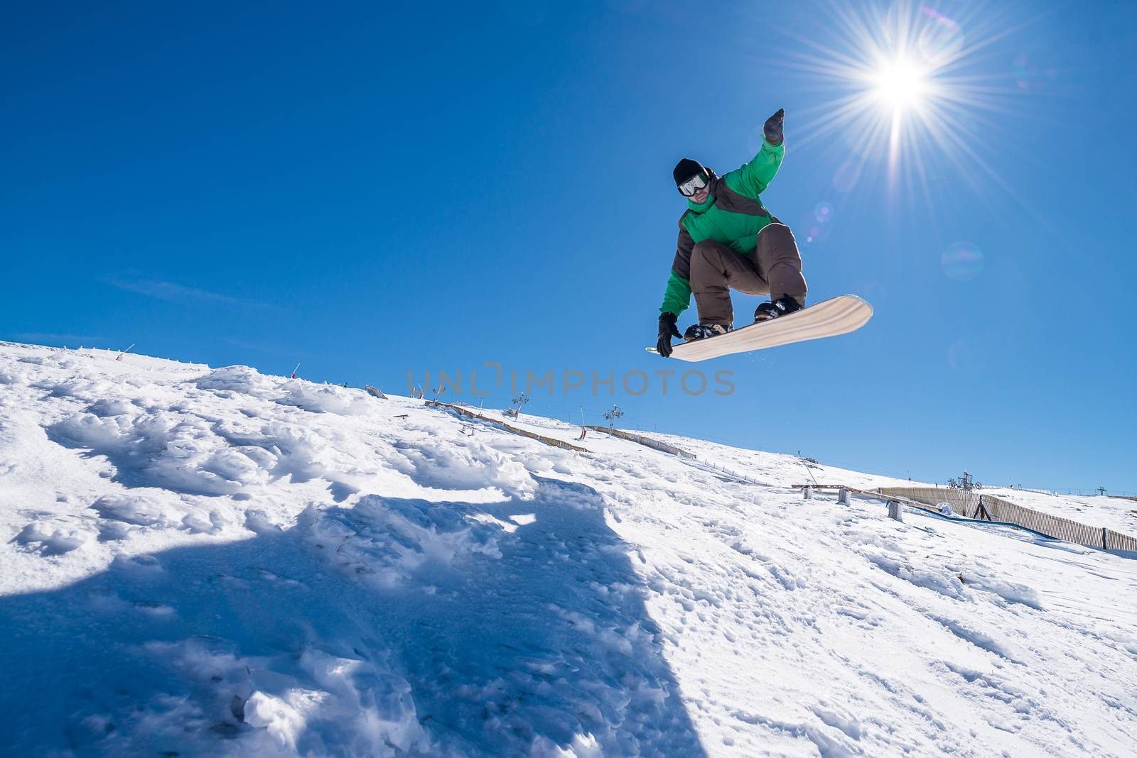 Snowboarder executing a radical jump against blue sky.