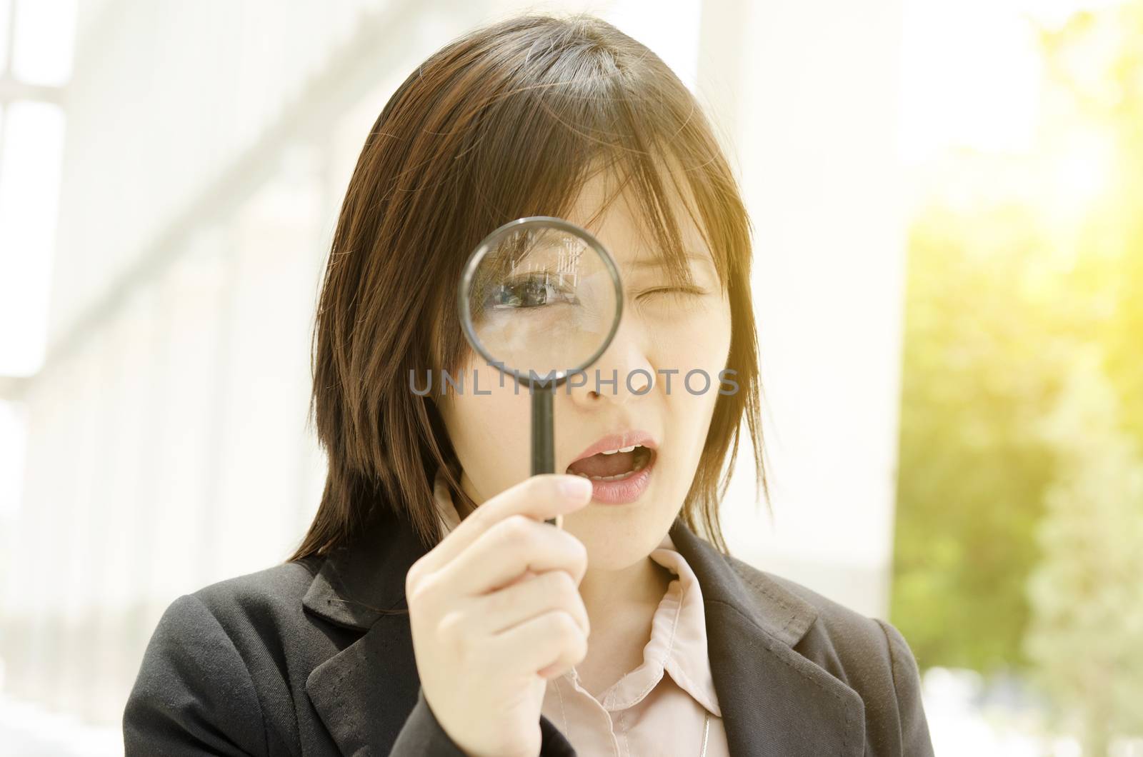 Asian female looking through magnifier glass by szefei