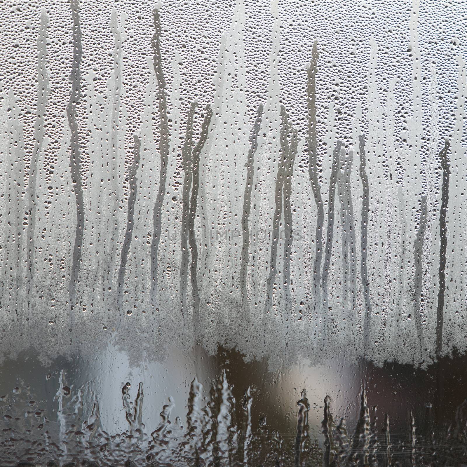 raindrops on dull misty glass of window