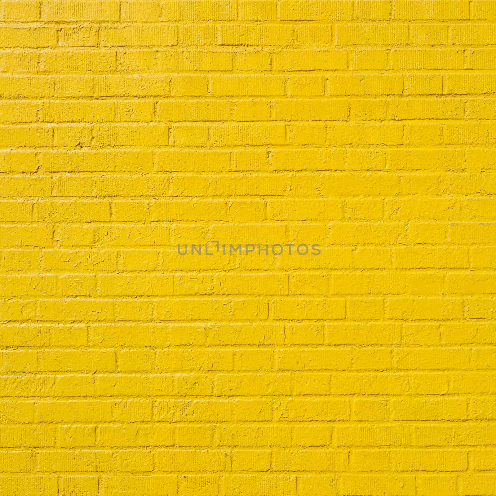 square part of yellow painted brick wall by ahavelaar