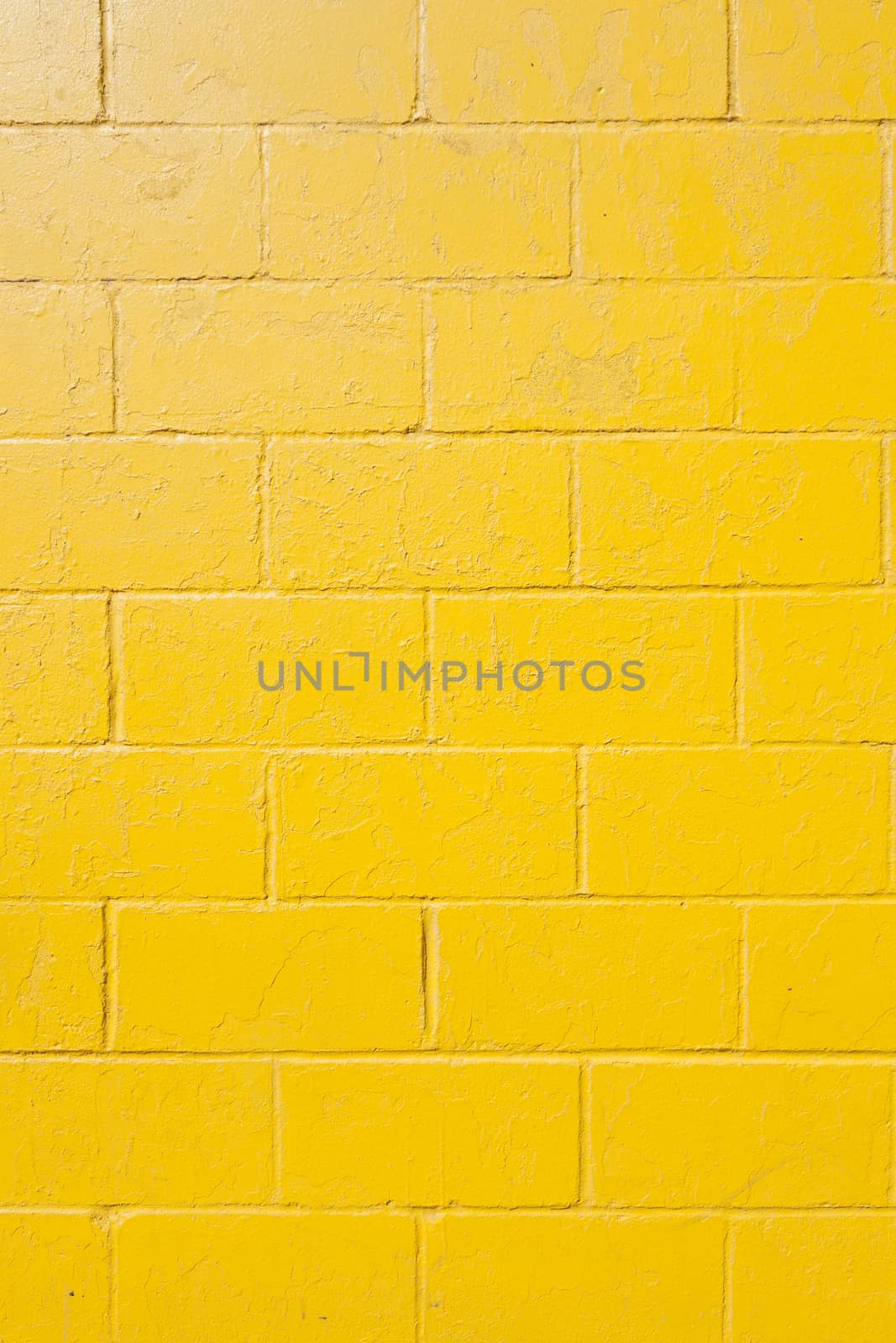 vertical part of bright yellow painted brick block wall