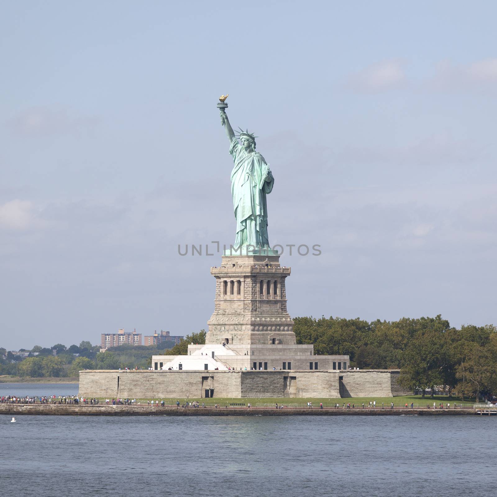 statue of miss liberty in new york city on sunny day with blue sky
