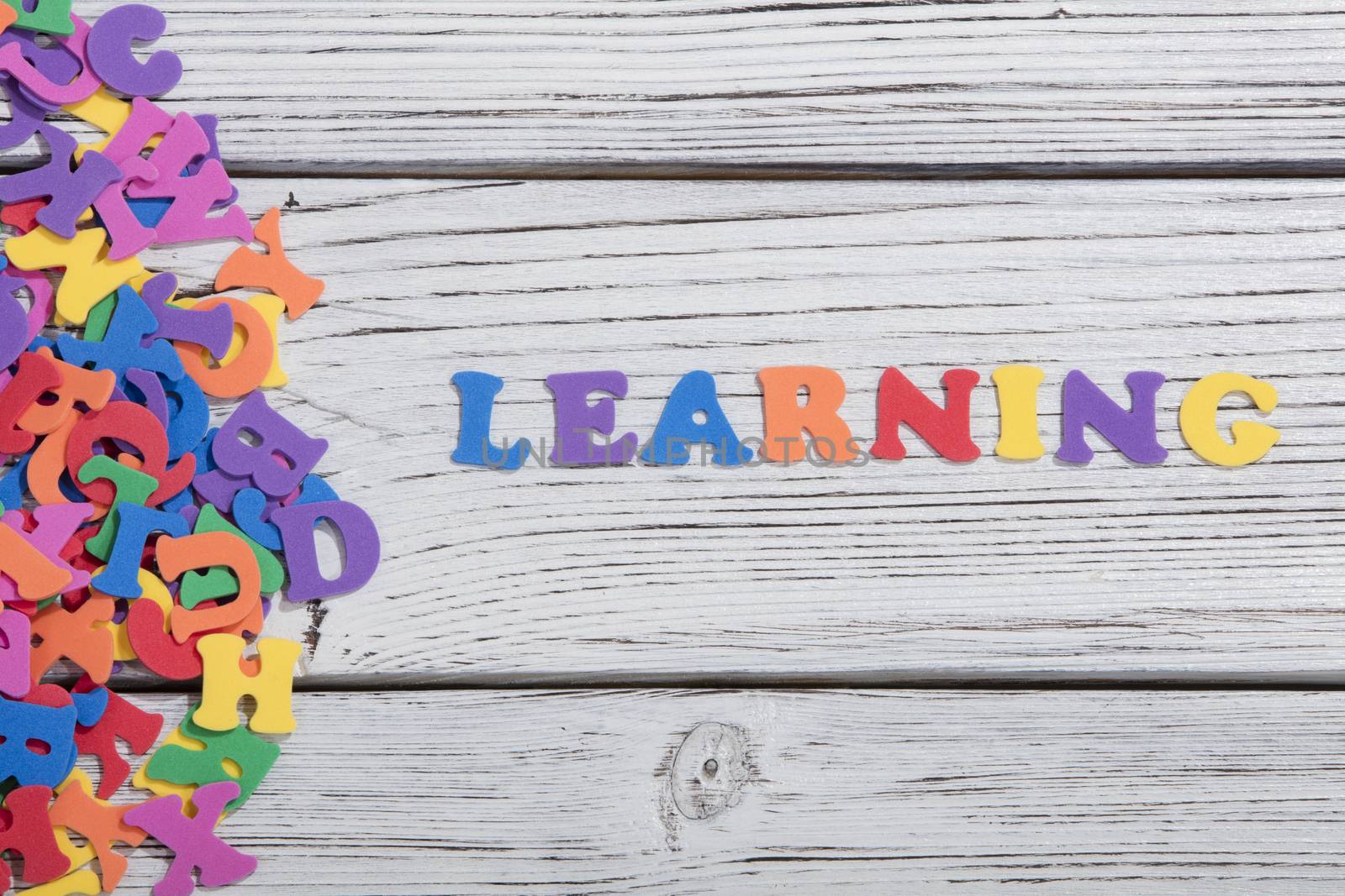 the colorful words learning made with colorful letters over white wooden board by senkaya