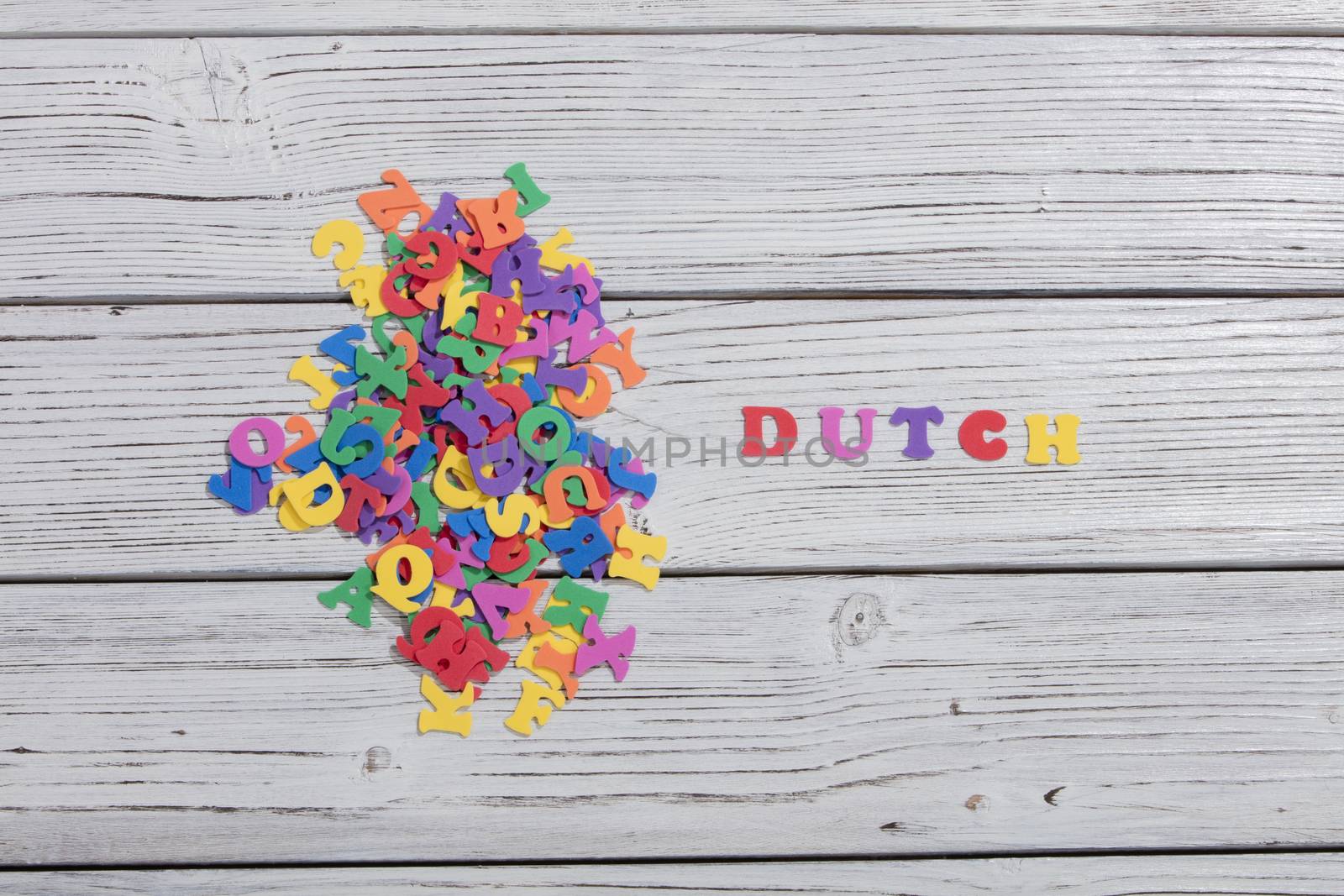 the colorful words dutch made with colorful letters over white wooden board by senkaya