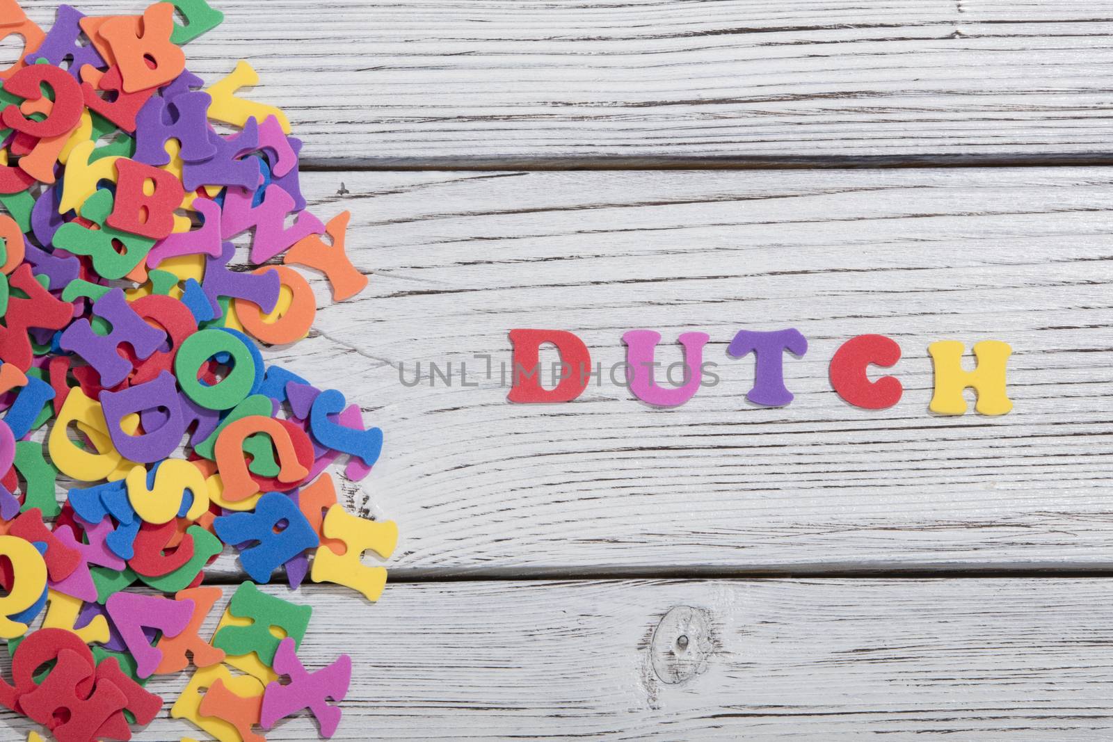 the colorful words dutch made with colorful letters over white wooden board by senkaya