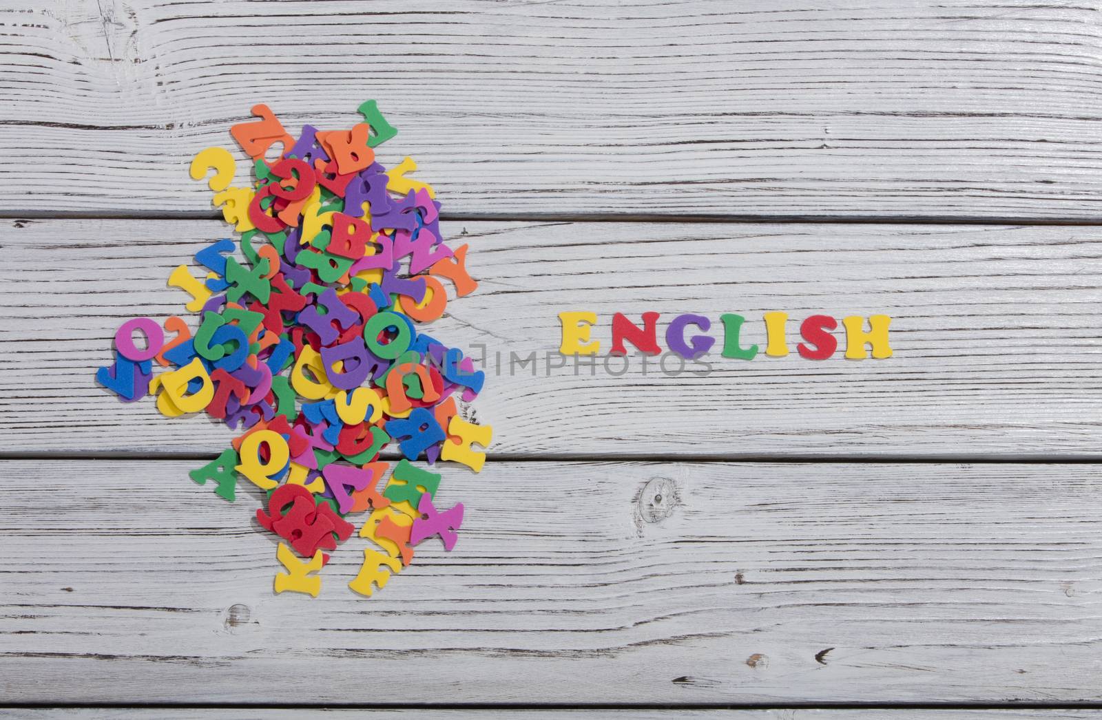 the colorful words english made with colorful letters over white wooden board by senkaya